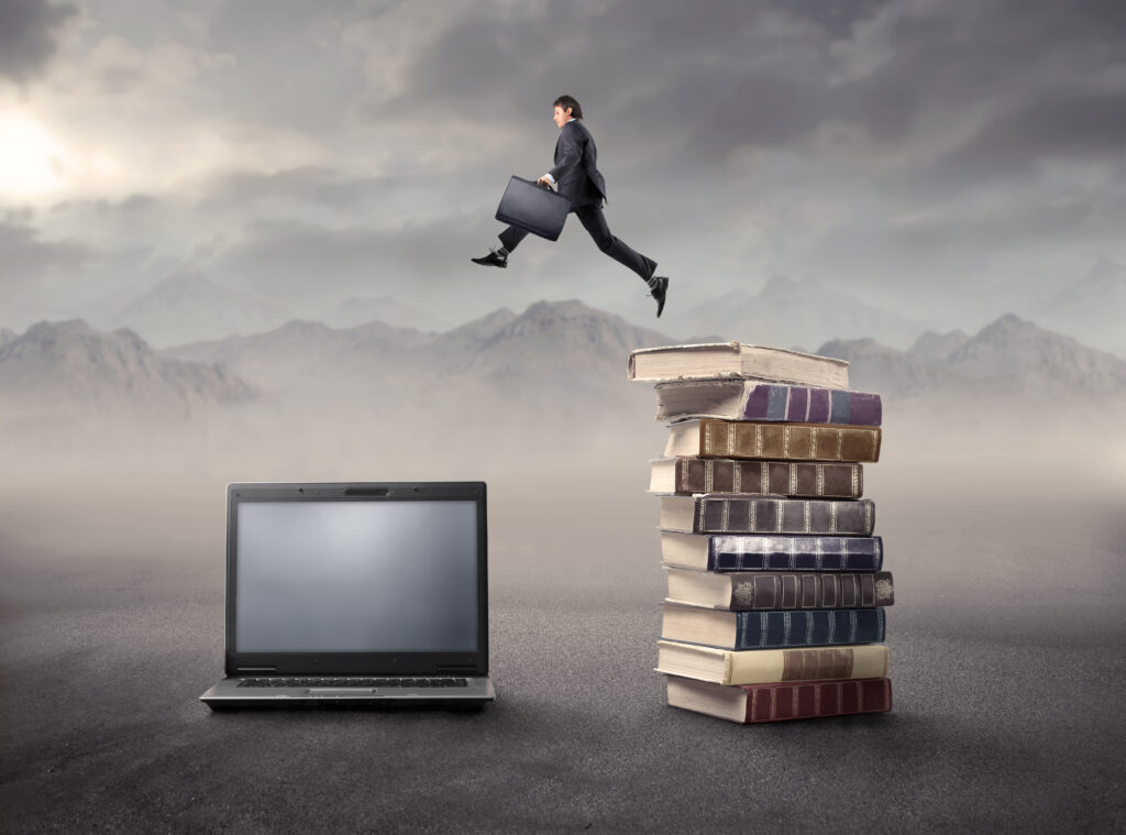 Businessman,Jumping,From,Some,Books,To,A,Laptop,In,A CEO's, Presidents & Business Owners